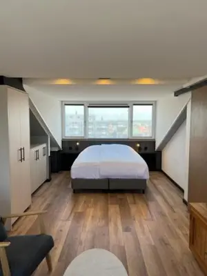 a bedroom with a bed in the middle of a room at Casa del Cisne 3 in Zandvoort