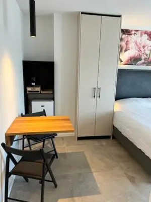 a bedroom with a table and a bed and a desk at Casa del Cisne 3 in Zandvoort