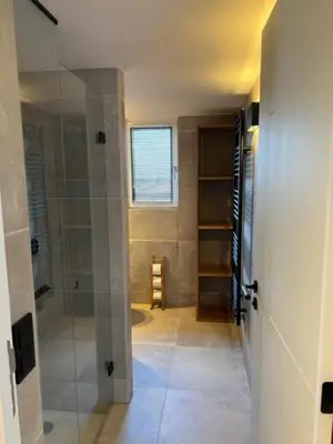 a bathroom with a walk in shower and a glass door at Casa del Cisne 3 in Zandvoort