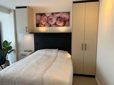 a bedroom with a bed and a painting of roses at Casa del Cisne 3 in Zandvoort