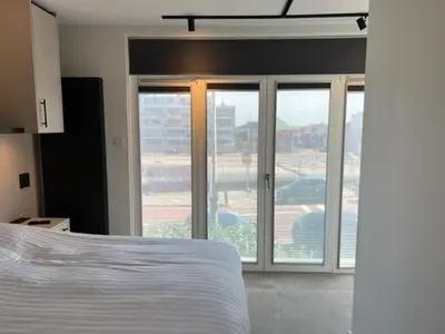 a bedroom with a bed and sliding glass doors at Casa del Cisne 3 in Zandvoort
