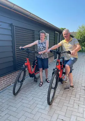 a man and a woman standing next to their bikes at B&B De Meije in Nieuwkoop