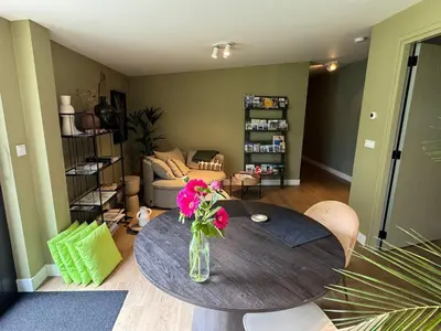 a living room with a table with a vase of flowers on it at B&B De Meije in Nieuwkoop