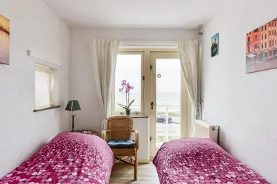 a bedroom with two beds and a window at Zee en Duin in Zandvoort