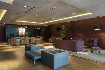 a lobby with a waiting room with couches and tables at DoubleTree by Hilton Amsterdam - NDSM Wharf in Amsterdam