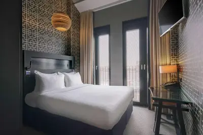 a hotel room with a bed and a desk and window at DoubleTree by Hilton Amsterdam - NDSM Wharf in Amsterdam
