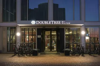 a building with a bunch of bikes parked outside of it at DoubleTree by Hilton Amsterdam - NDSM Wharf in Amsterdam