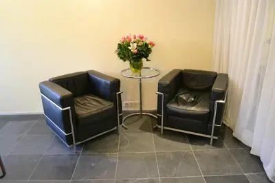 two chairs and a table with a vase of flowers at Luxueuze Studio Herengracht in Amsterdam