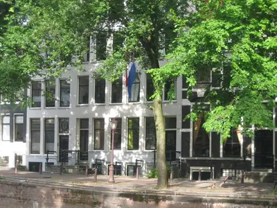 a white building with a flag in front of it at Luxueuze Studio Herengracht in Amsterdam