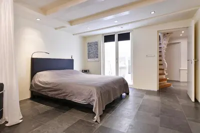 a bedroom with a large bed and a staircase at Luxueuze Studio Herengracht in Amsterdam