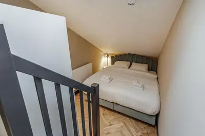 a small bedroom with a bed and a staircase at Bens The Walton in Amsterdam