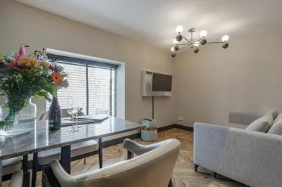 a dining room with a table with a vase of flowers at Bens The Walton in Amsterdam