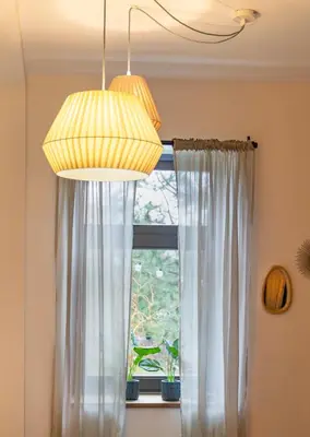 a chandelier and a window with a white curtain at Have a nice stay! - Studio tussen de bossen en de bollenvelden in Noordwijkerhout
