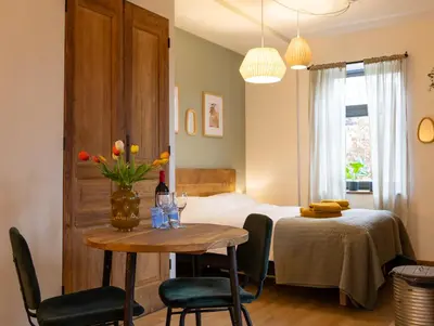 a bedroom with a bed and a table and chairs at Have a nice stay! - Studio tussen de bossen en de bollenvelden in Noordwijkerhout