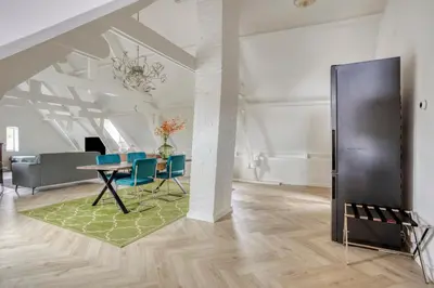 a living room with a table and blue chairs at Top floor appartment Edam in Edam