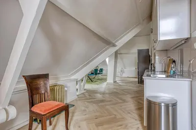 a kitchen with a staircase with a chair and a sink at Top floor appartment Edam in Edam