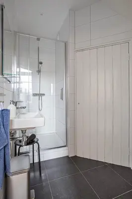 a white bathroom with a sink and a shower at Top floor appartment Edam in Edam