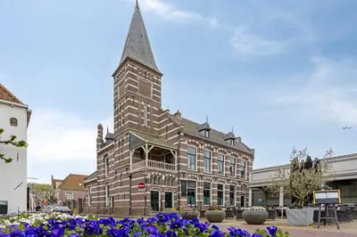 a large brick building with a tall steeple at Top floor appartment Edam in Edam