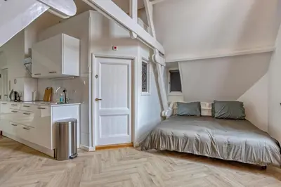 a small bedroom with a bed and a kitchen at Top floor appartment Edam in Edam
