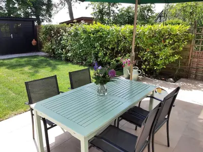 a blue table with chairs and a vase of flowers on it at Stylish holiday home by the sea in Tuitjenhorn