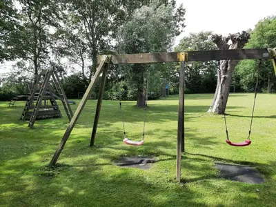 an empty swing set in a park at Stylish holiday home by the sea in Tuitjenhorn