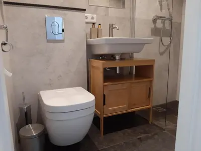 a bathroom with a white toilet and a sink at Stylish holiday home by the sea in Tuitjenhorn