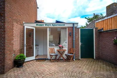 a patio with two chairs and a happy day apartment at Happy Days Apartment - Luxurious - Free parking on own property in Zandvoort
