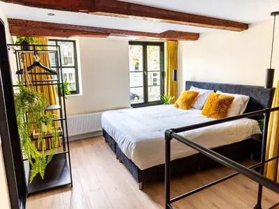 a bedroom with a bed and some plants at Appartement Wolf in Alkmaar