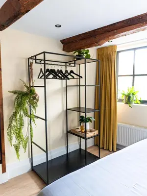 a black shelving unit in a bedroom with plants at Appartement Wolf in Alkmaar