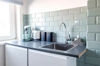 a kitchen counter with a sink in a kitchen at Albatros aan Zee - Apartment in Zandvoort