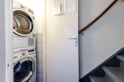 a laundry room with a washer and dryer at Albatros aan Zee - Apartment in Zandvoort