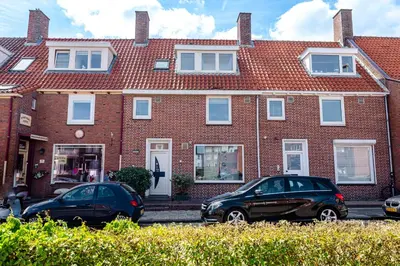 two cars parked in front of a brick building at Albatros aan Zee - Apartment in Zandvoort