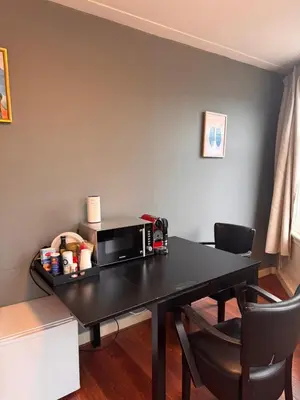 a room with a table with a microwave and chairs at Central B&B Apartment in Amsterdam in Amsterdam