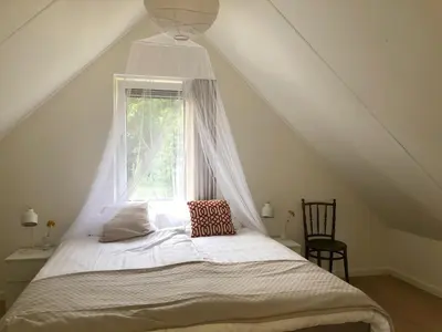 a bed in a room with a window at Bungalow 82 op Recreatiepark De Wielen in Sint Maarten