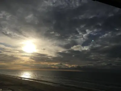 a sunset on the beach with a cloudy sky at Zwarte Vis in Zandvoort