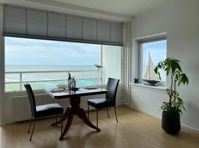 a dining room with a table and a sailboat in a window at Zwarte Vis in Zandvoort