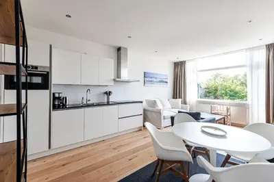 a kitchen and living room with a table and chairs at The apartment Shell 42 in Zandvoort