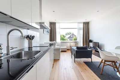 a kitchen with a sink and a living room at The apartment Shell 42 in Zandvoort