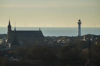 a view of a city with a lighthouse and the ocean at Super de luxe privékamer op een toplocatie - Room 1 in Egmond aan Zee