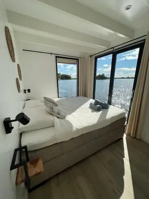 a bedroom with a large bed and a large window at Surla houseboat 
