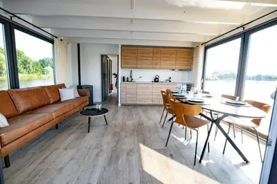 a living room with a couch and a table with chairs at Surla houseboat 
