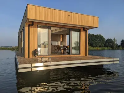 a house on a dock on a body of water at Surla houseboat 