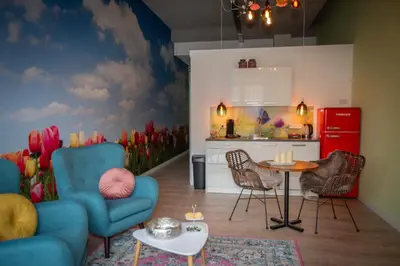 a kitchen with a blue chair and a table and a red refrigerator at Bed & Breakfast Bakker Meijer in Heemskerk
