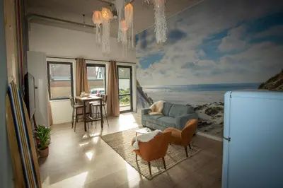 a living room with a painting of the ocean at Bed & Breakfast Bakker Meijer in Heemskerk
