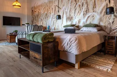 a bedroom with a large bed with a wooden wall at Bed & Breakfast Bakker Meijer in Heemskerk