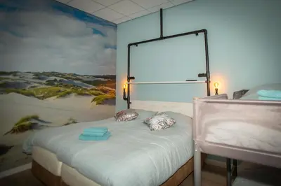 a room with a bed with a painting on the wall at Bed & Breakfast Bakker Meijer in Heemskerk