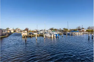 a group of boats docked at a dock on the water at Oase aan de Kaag in Warmond