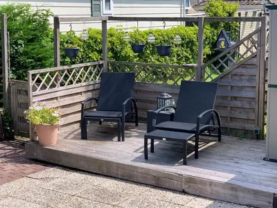 two chairs sitting on a wooden deck with plants at Oase aan de Kaag in Warmond
