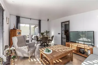a living room with a large television and a table at Oase aan de Kaag in Warmond