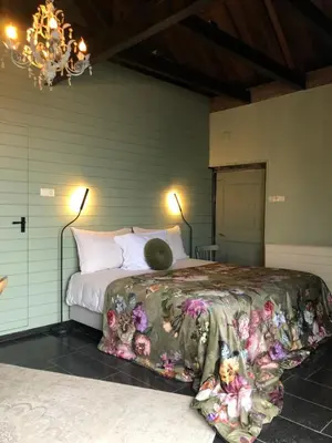 a bedroom with a bed with a comforter on it at B&B De Beijersche Stee, Logies aan de Waterkant in Stolwijk